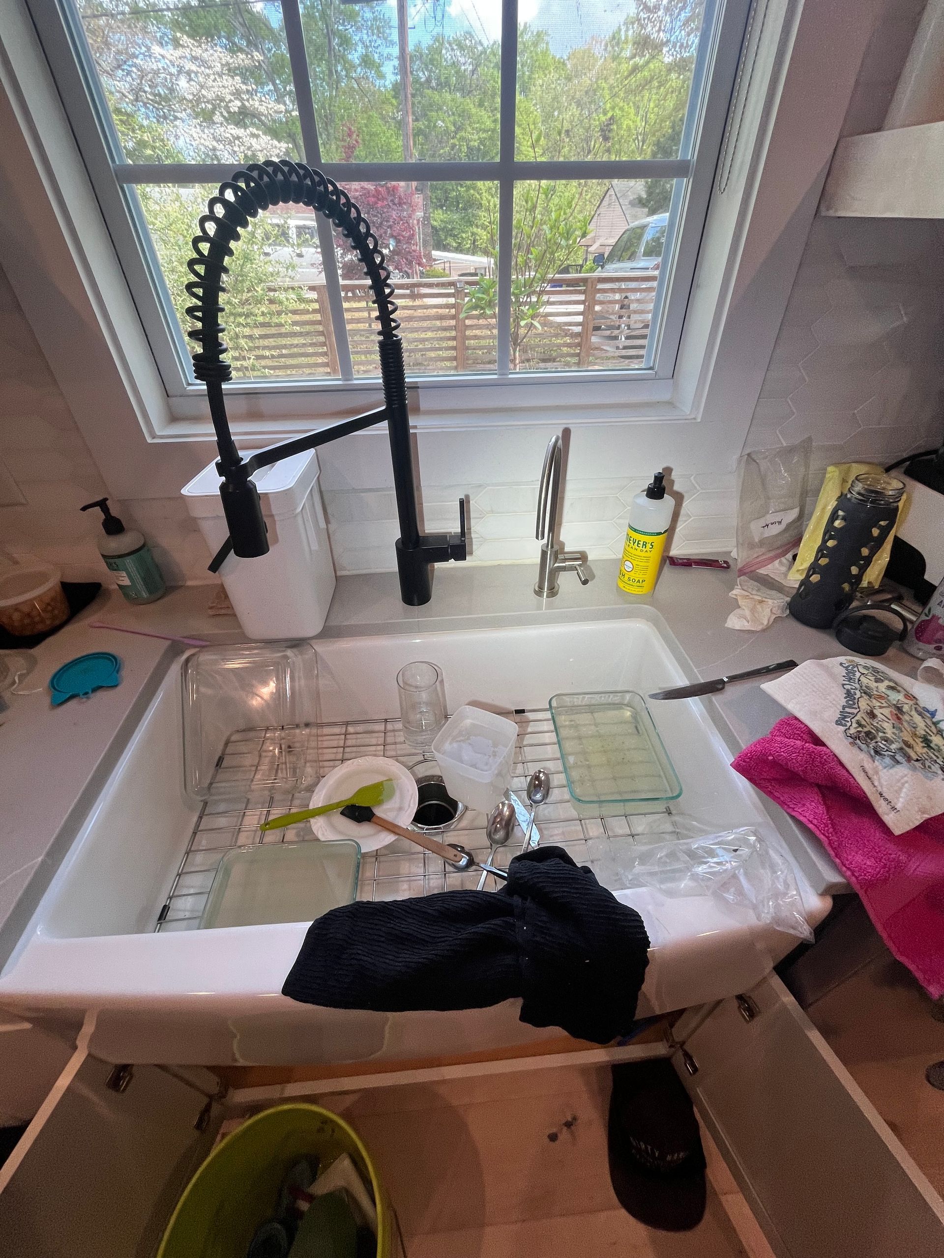 A kitchen sink with a faucet and a window in the background.