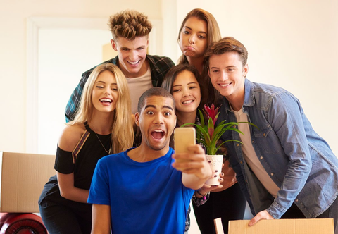 A group of college kids take a selfie while moving into their new rental
