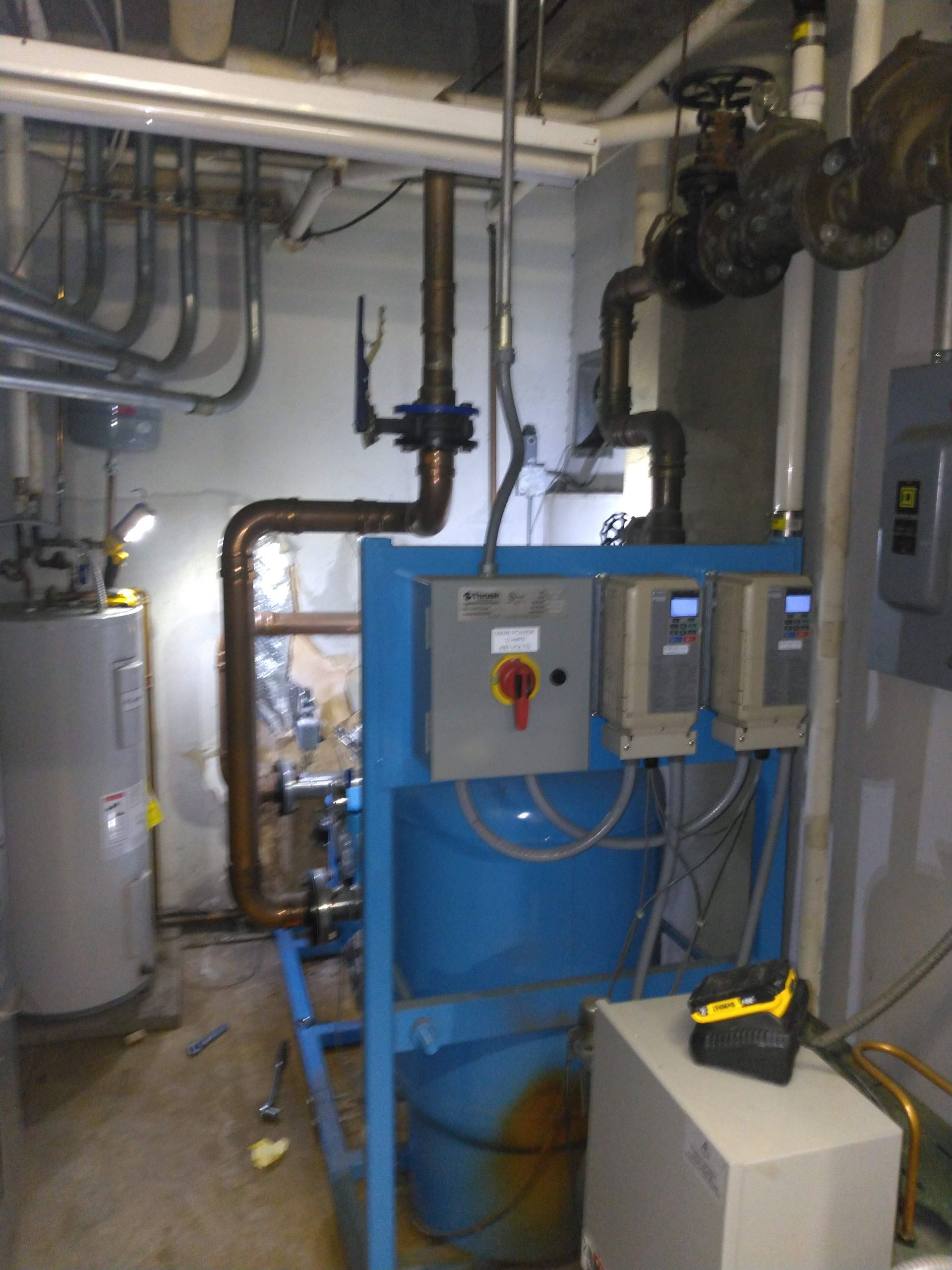 A room with lots of pipes and a blue tank