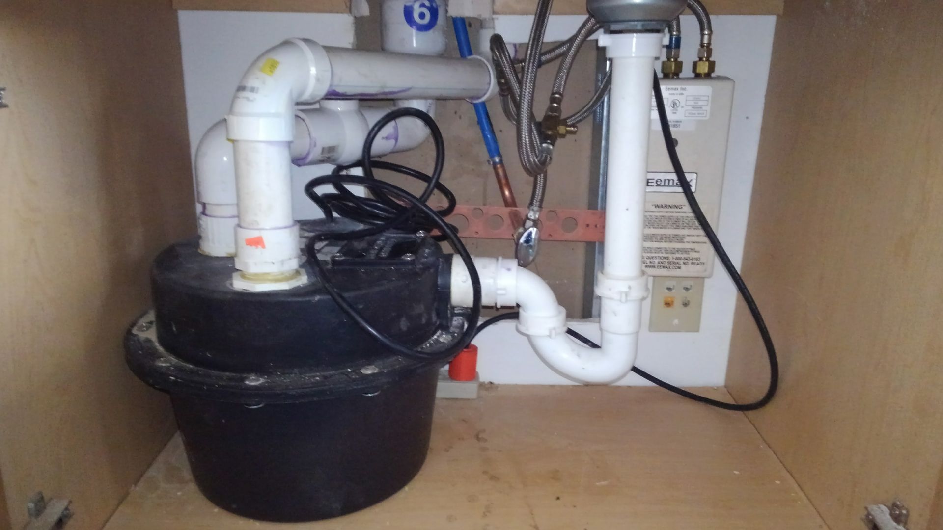 A sink with a drain and pipes underneath it