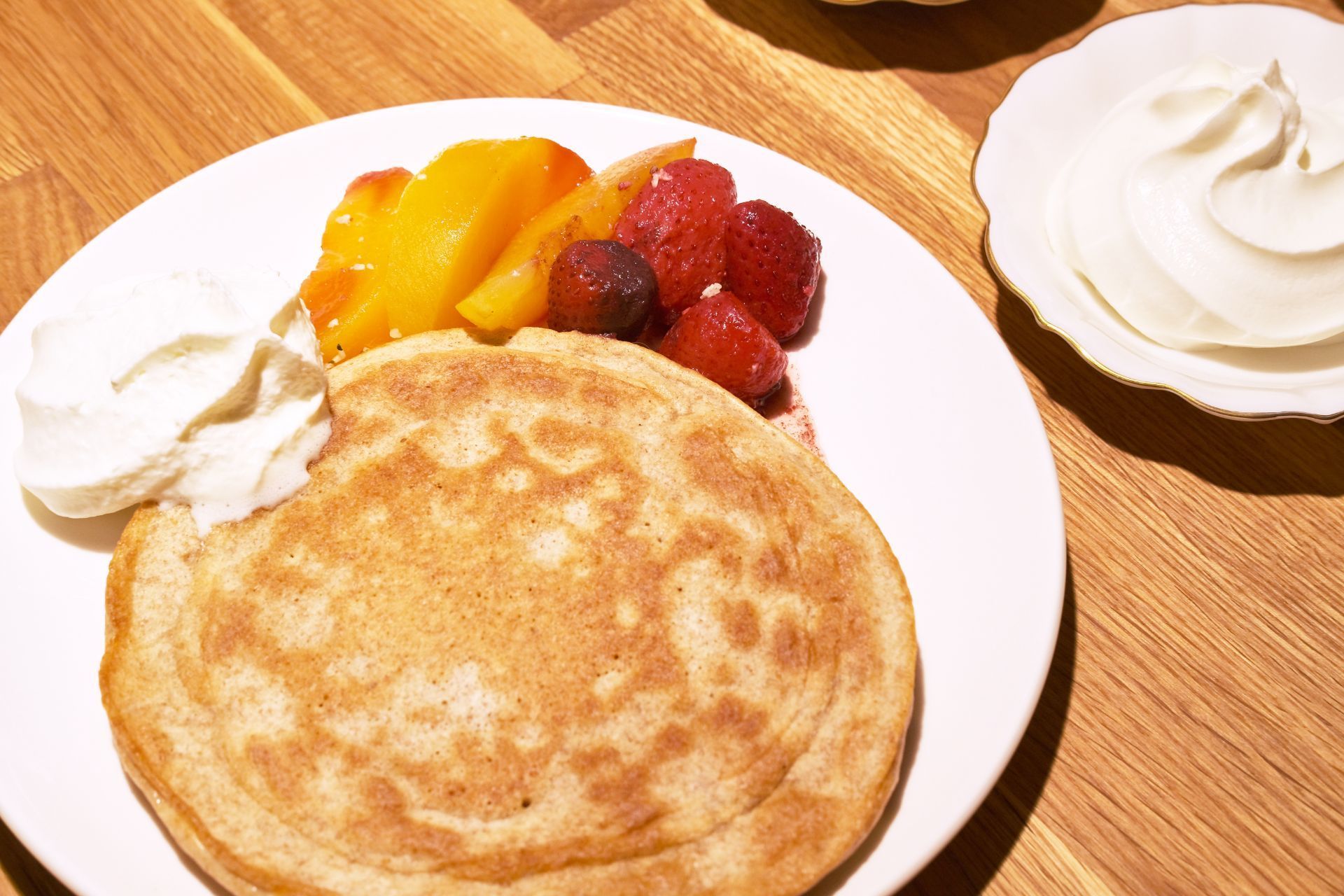 A pancake with fruit and whipped cream on a plate
