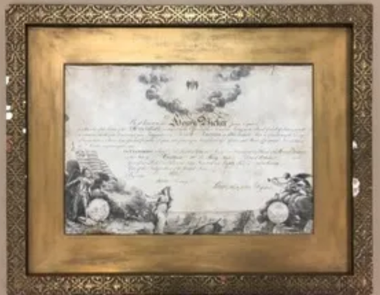 A framed piece of paper with a gold frame on a wall.