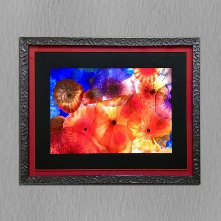 A picture of flowers in a black and red frame