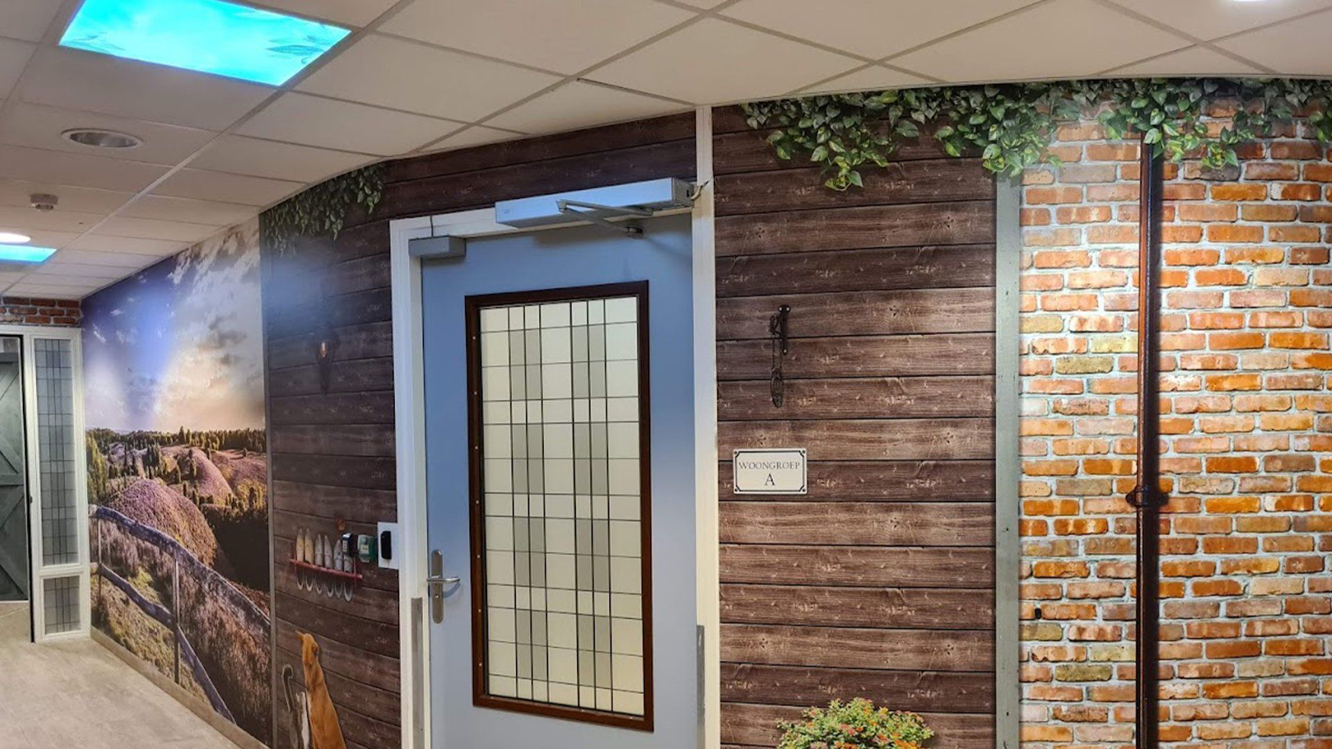 Een gang met een blauwe deur en een bakstenen muur.