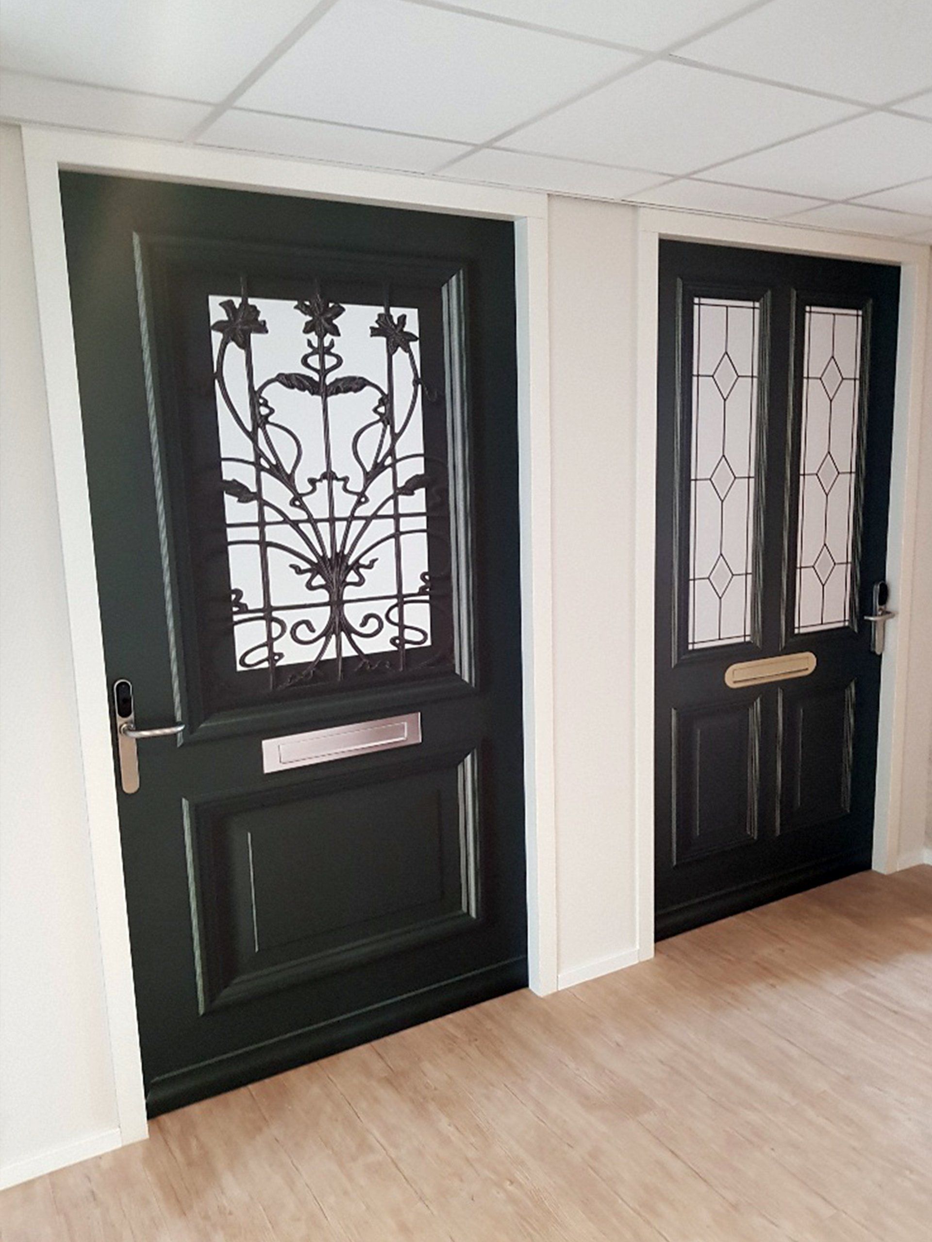 Een gang met twee zwarte deuren en een houten vloer.