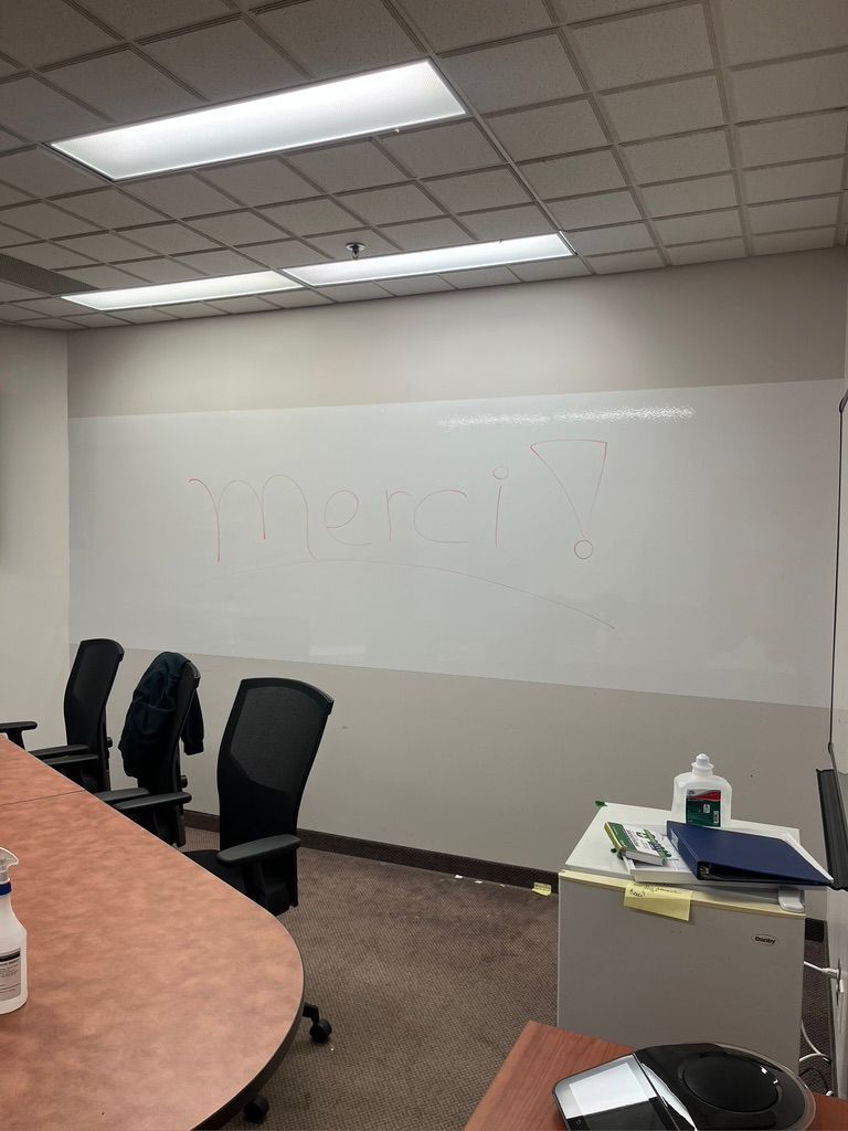 Une salle de conférence avec un tableau blanc et des chaises