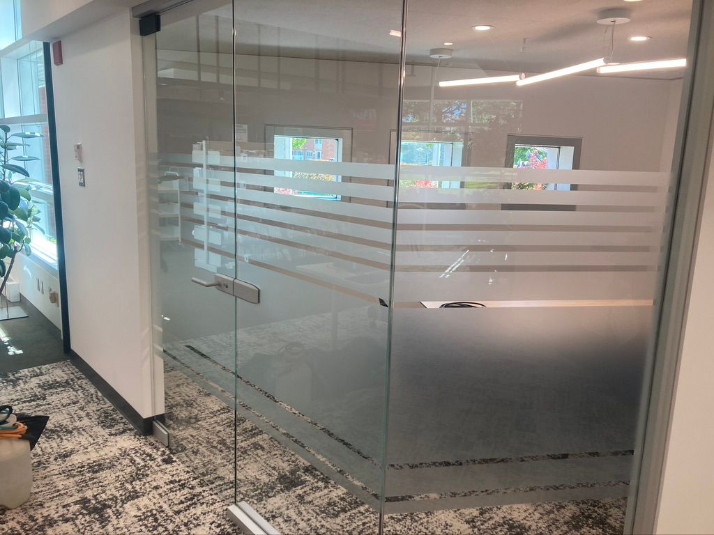 Une porte vitrée avec un motif rayé dans une pièce.