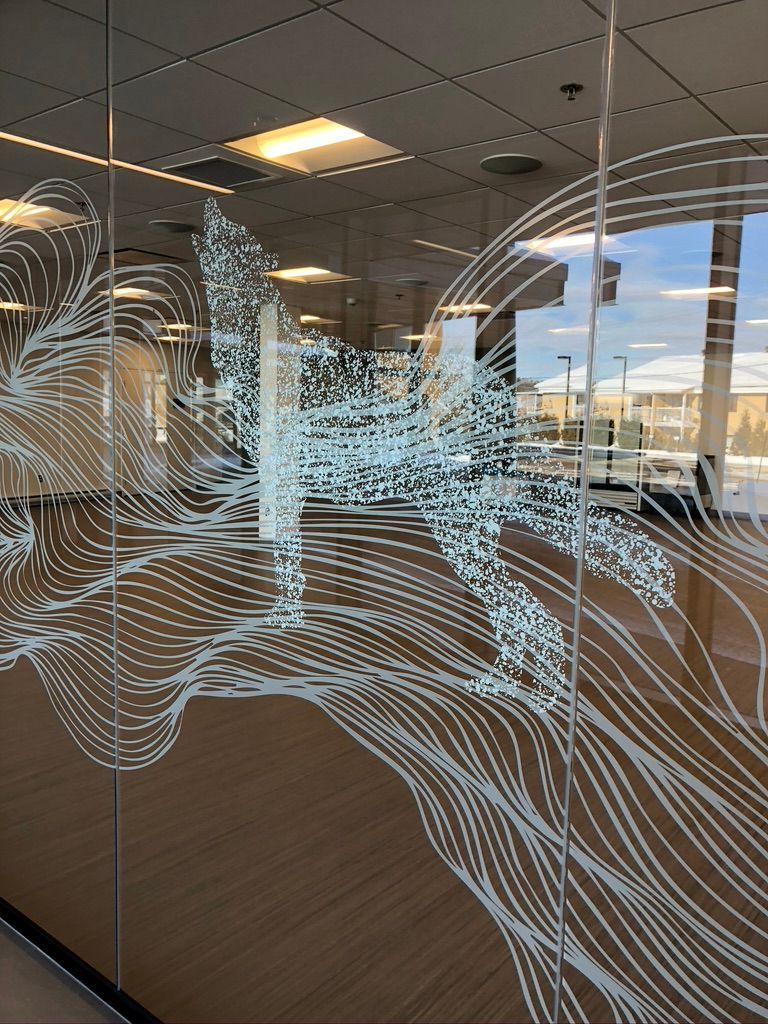 Un mur de verre avec un dessin dessus dans une pièce.