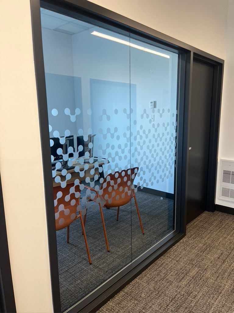 Une salle de conférence avec un mur en verre et des chaises.