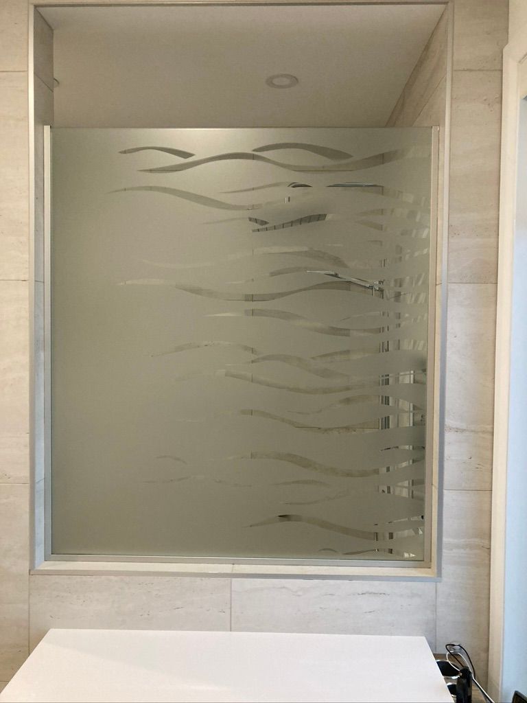 Une salle de bain avec une cabine de douche et une fenêtre avec un dessin dessus.