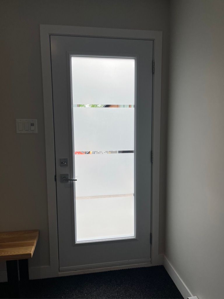 Une porte avec un motif de vitrail se trouve dans un couloir.