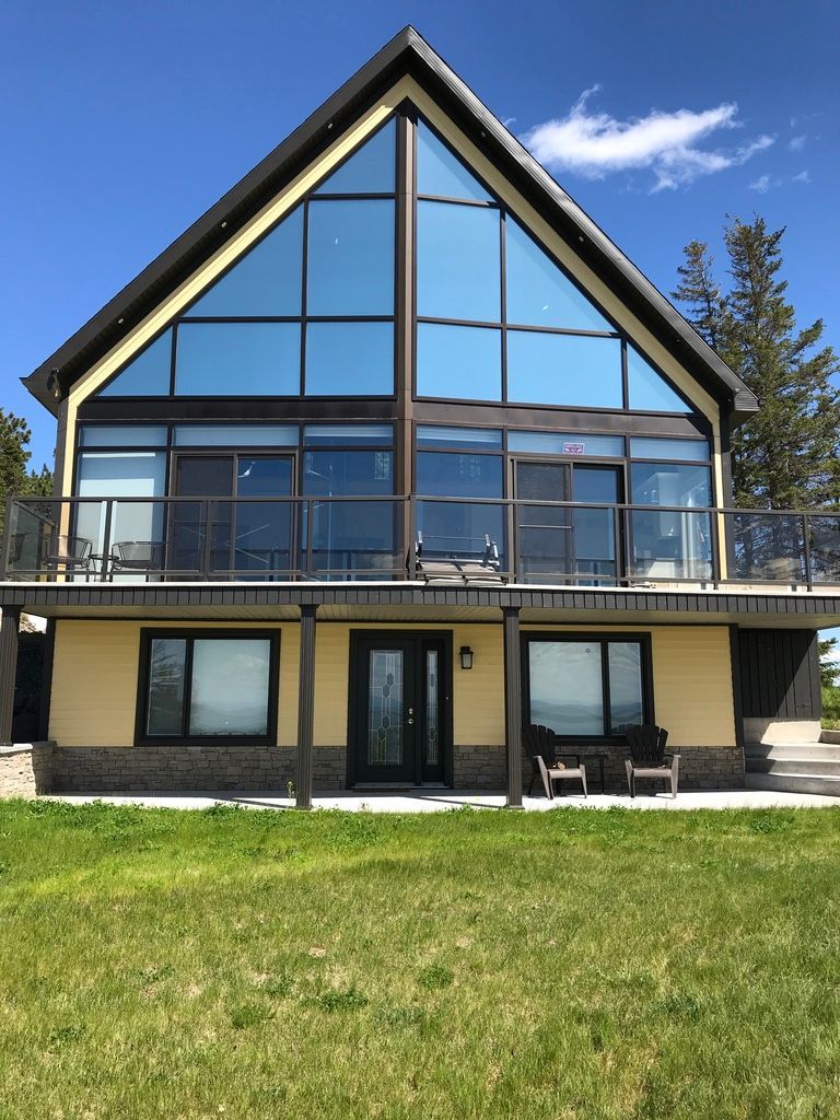 Une grande maison avec un toit en forme de triangle et beaucoup de fenêtres