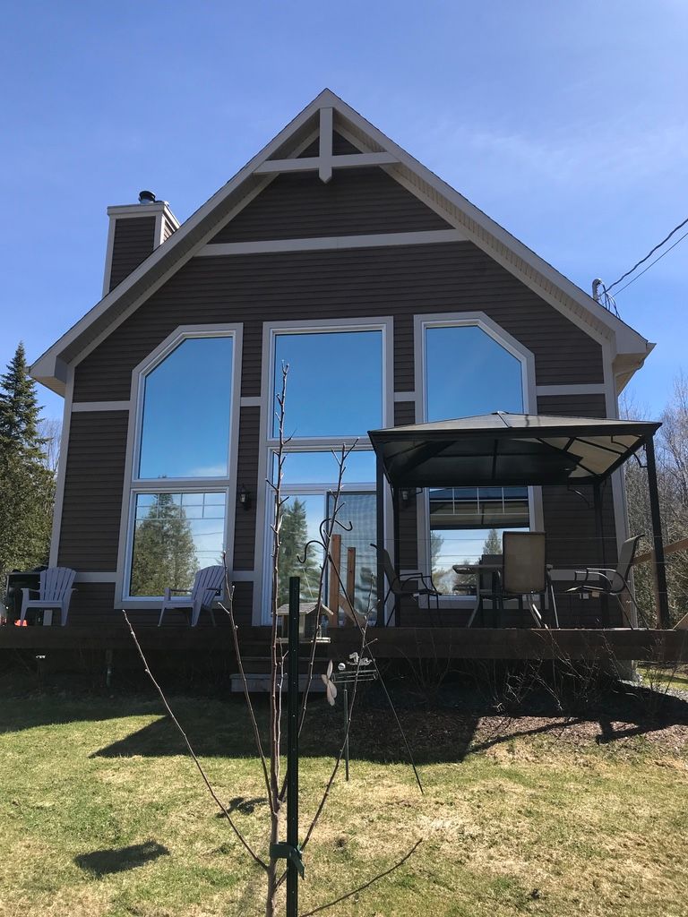 Une grande maison avec une grande terrasse et un belvédère devant.