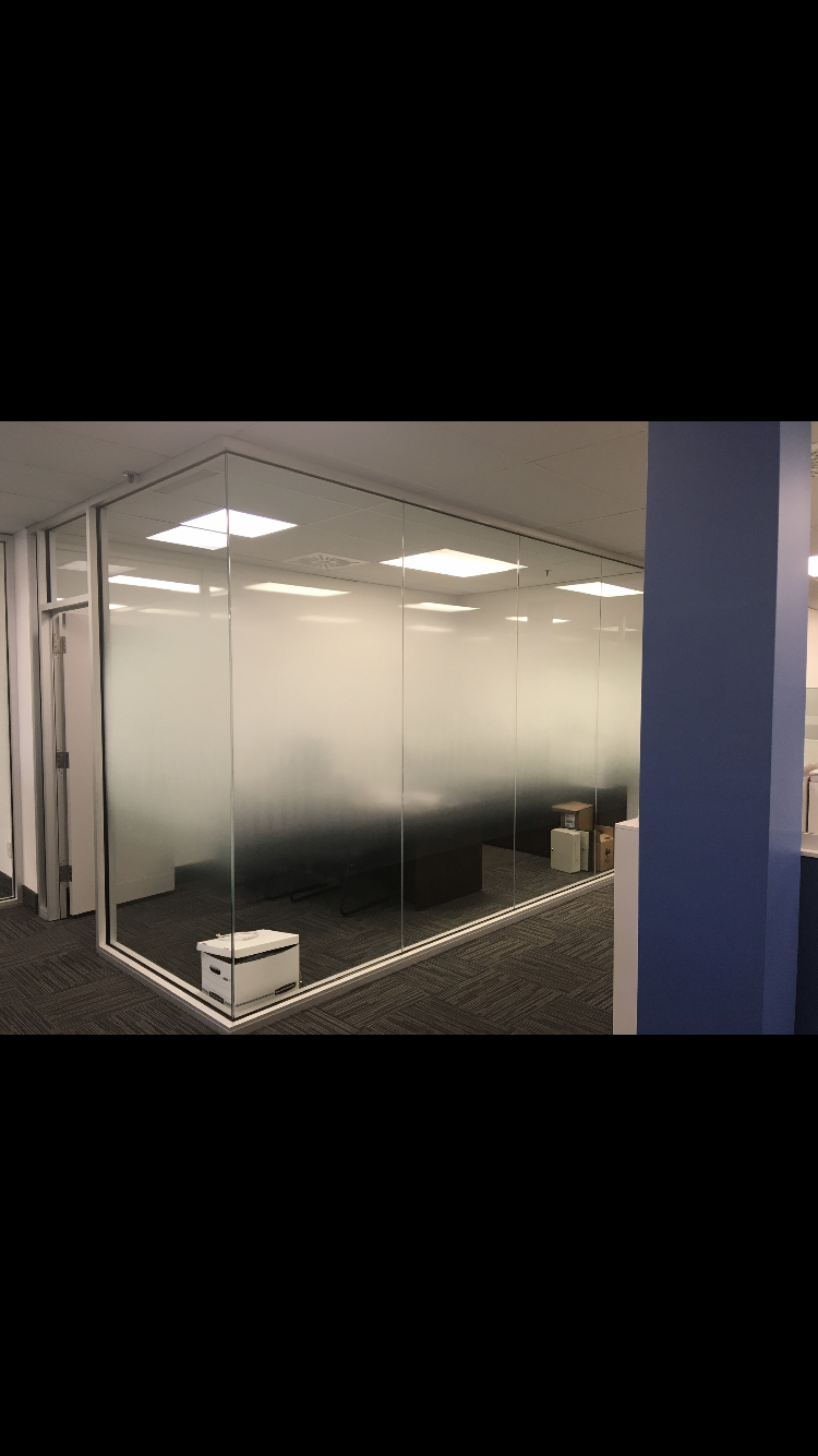 Une pièce avec un mur en verre et un canapé dedans.