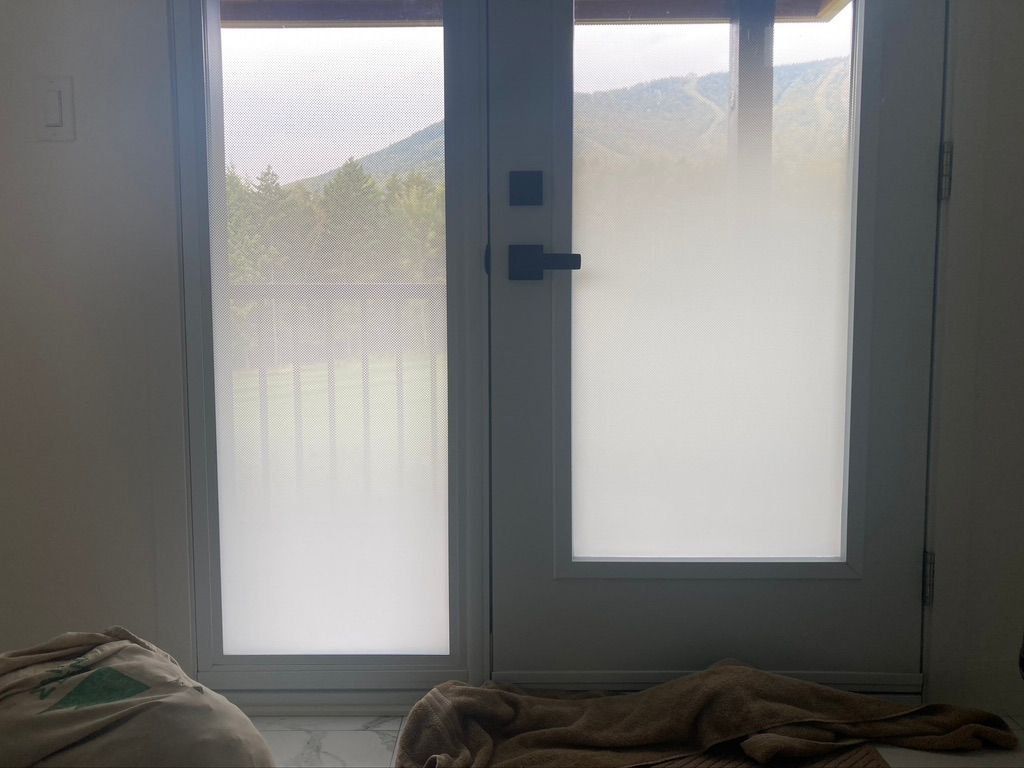 Une chambre avec une porte coulissante en verre et un lit.