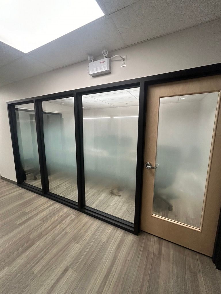 Une pièce avec beaucoup de fenêtres et une porte.