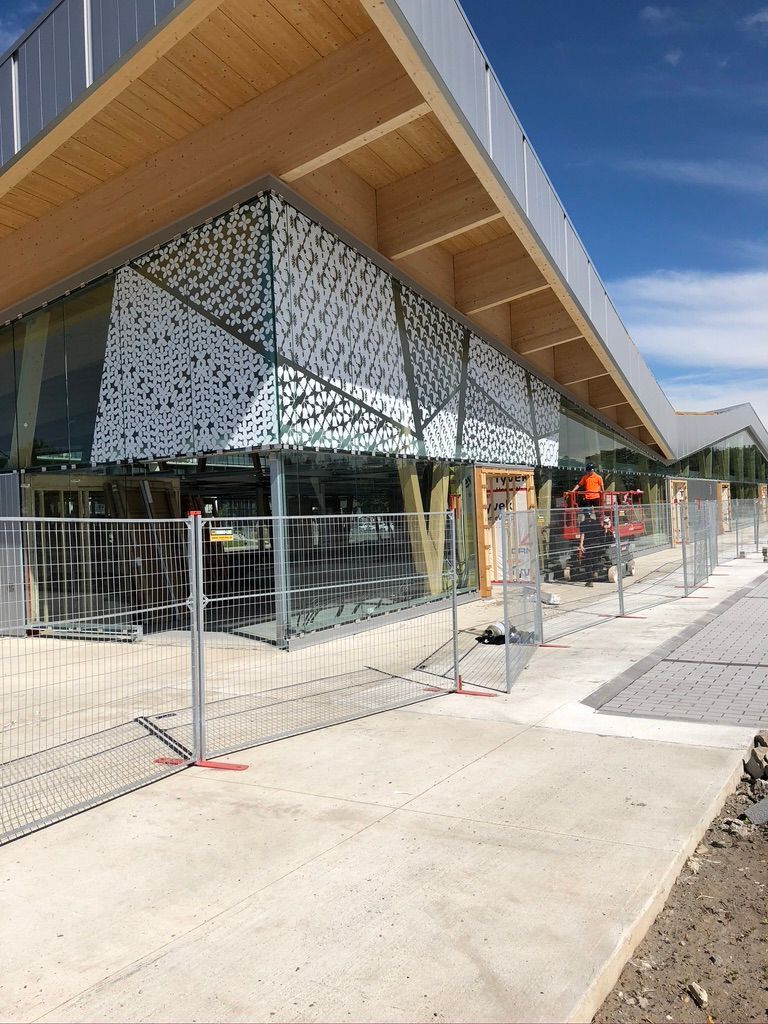 Un bâtiment moderne en construction présente des panneaux géométriques blancs décoratifs, 