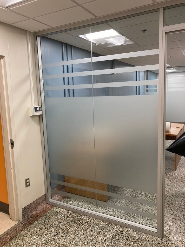 Un mur de verre avec un motif rayé dessus dans une pièce.