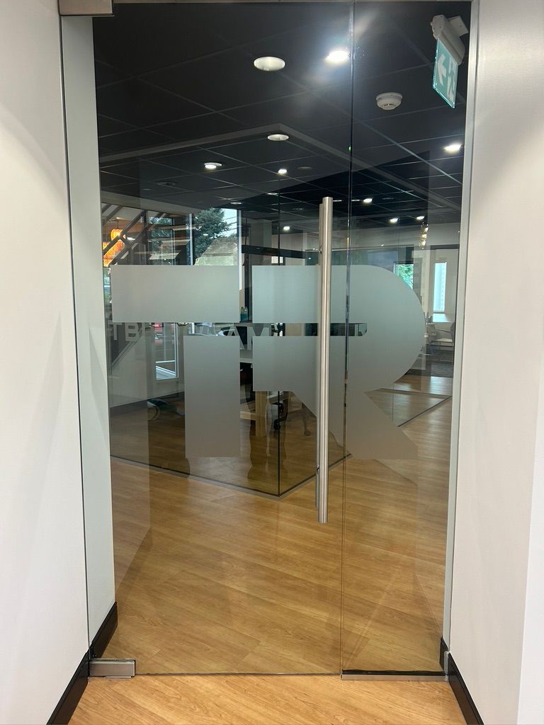 Une porte vitrée avec une flèche dessus dans un couloir.