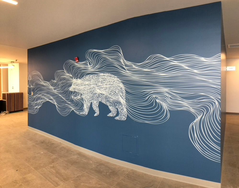 Un mur bleu avec une peinture d'un ours dessus.
