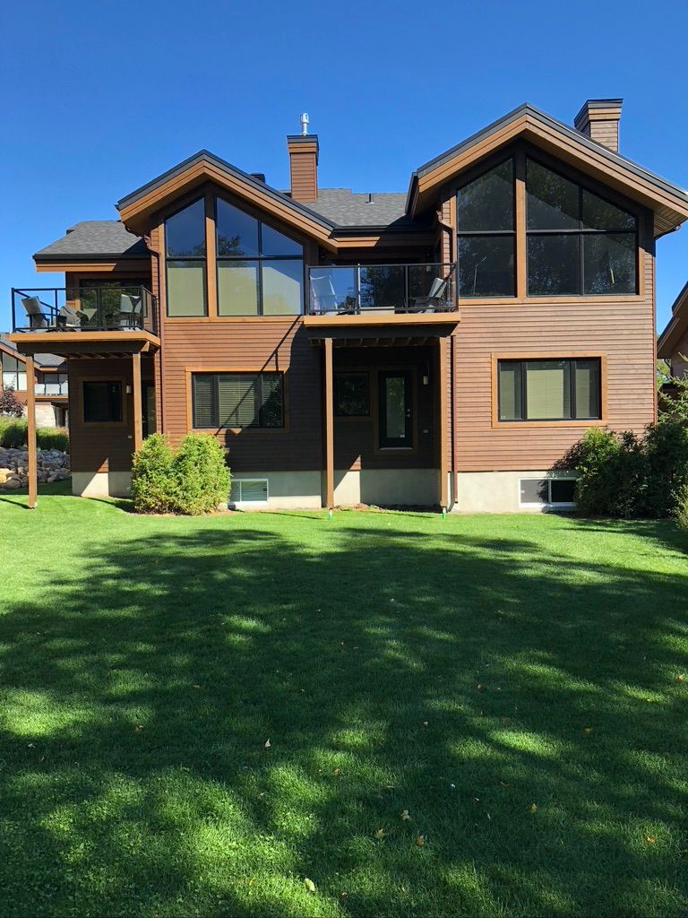 Une grande maison avec beaucoup de fenêtres et une grande pelouse devant elle