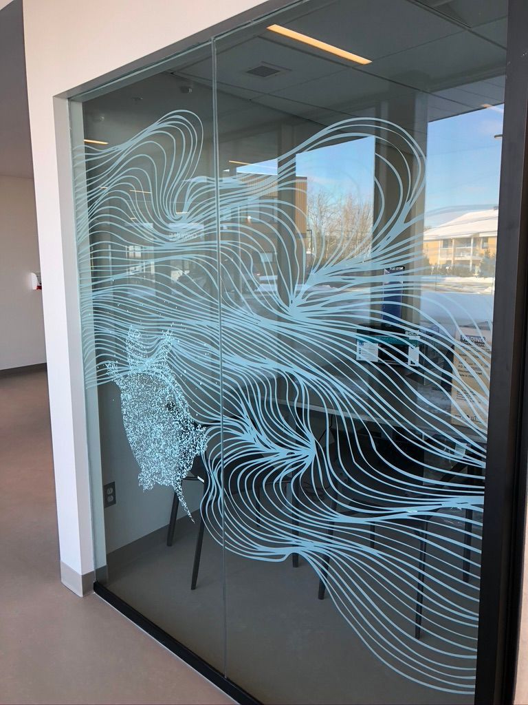 Une porte vitrée avec un dessin dessus dans une pièce.