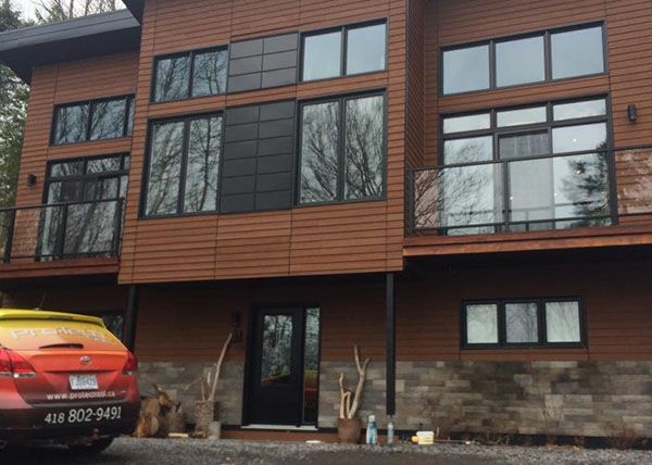 Une grande maison avec une voiture garée devant.