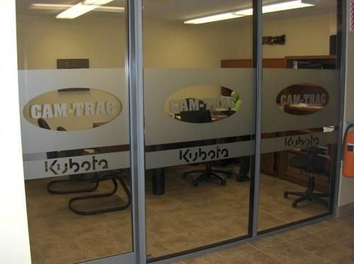 Une pièce avec une porte coulissante en verre sur laquelle est écrit cam trac