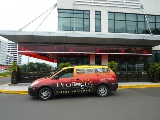 Une camionnette pro-tech est garée devant un bâtiment