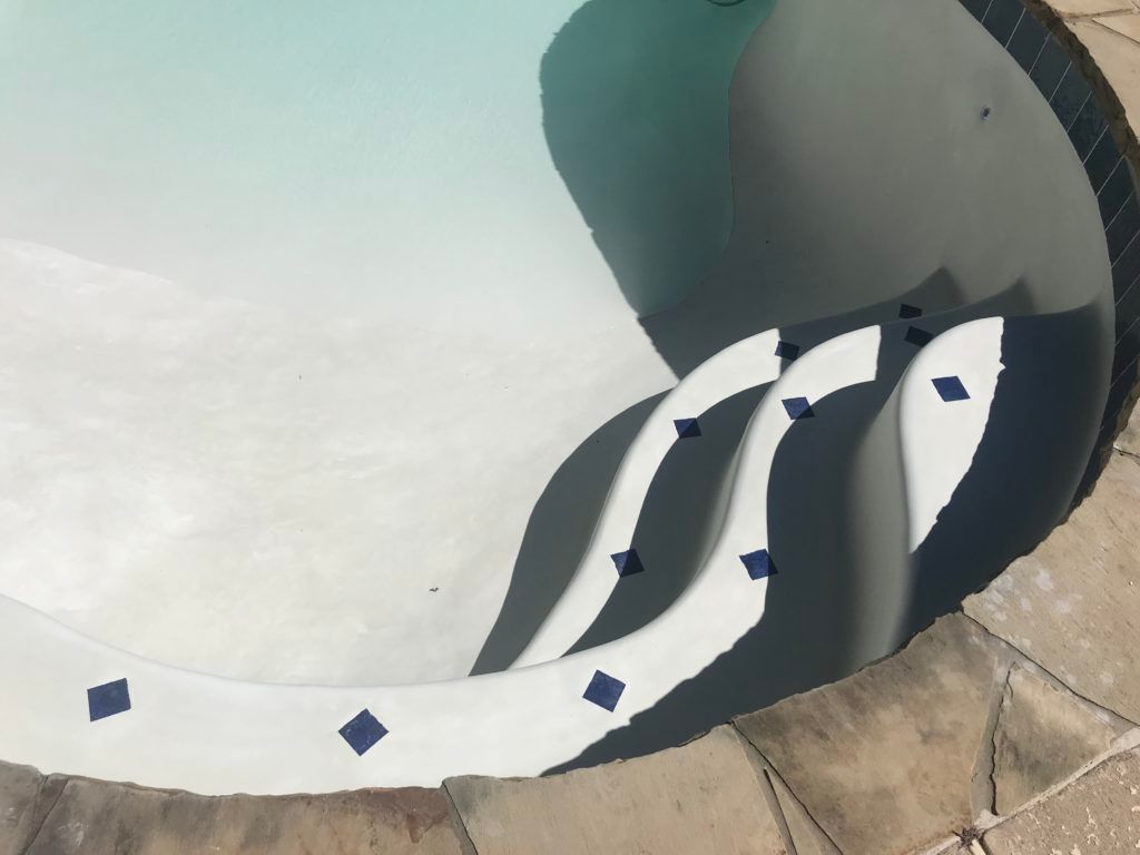 A swimming pool with blue and white tiles on the edge