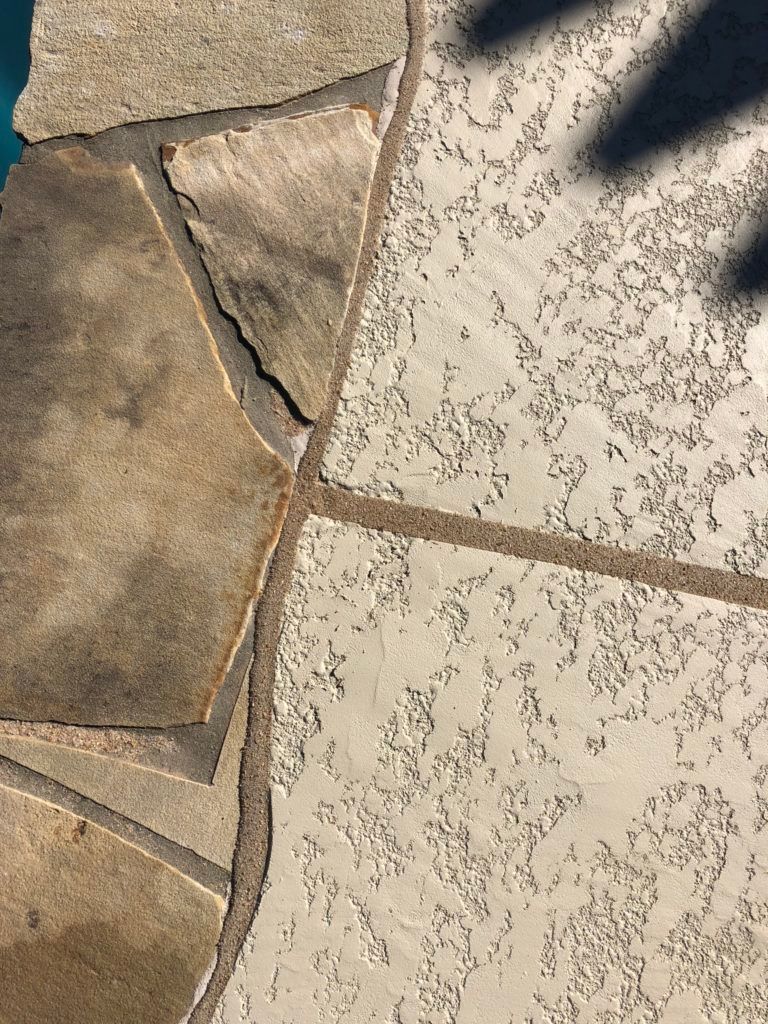 A close up of a stone walkway next to a pool.