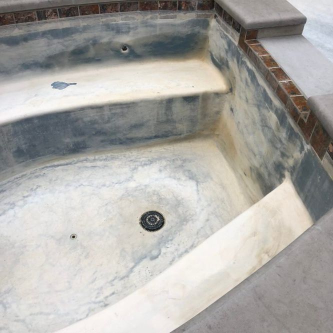 A bathtub with a drain in the middle of it