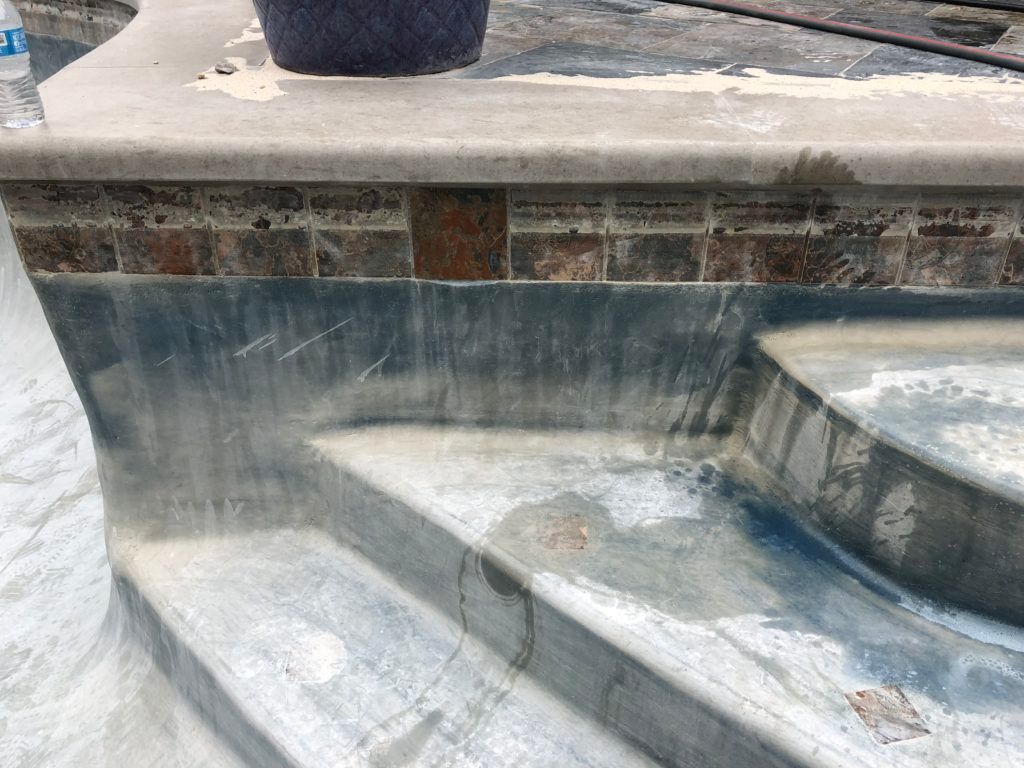 A swimming pool is being remodeled and the steps are being painted.