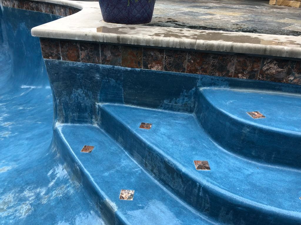 A blue staircase leading up to a swimming pool.