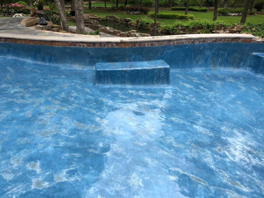 A large blue swimming pool with stairs leading up to it.