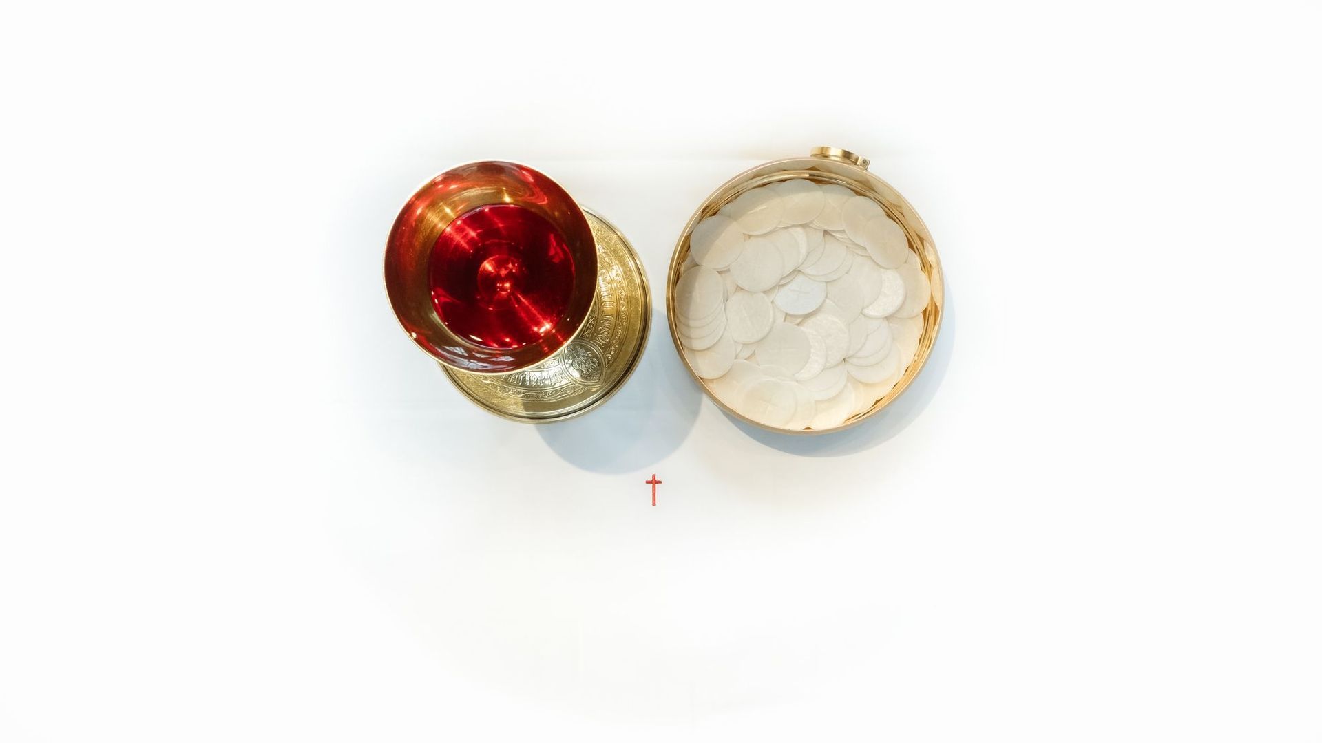A red bowl and a white bowl with a cross on a white background.