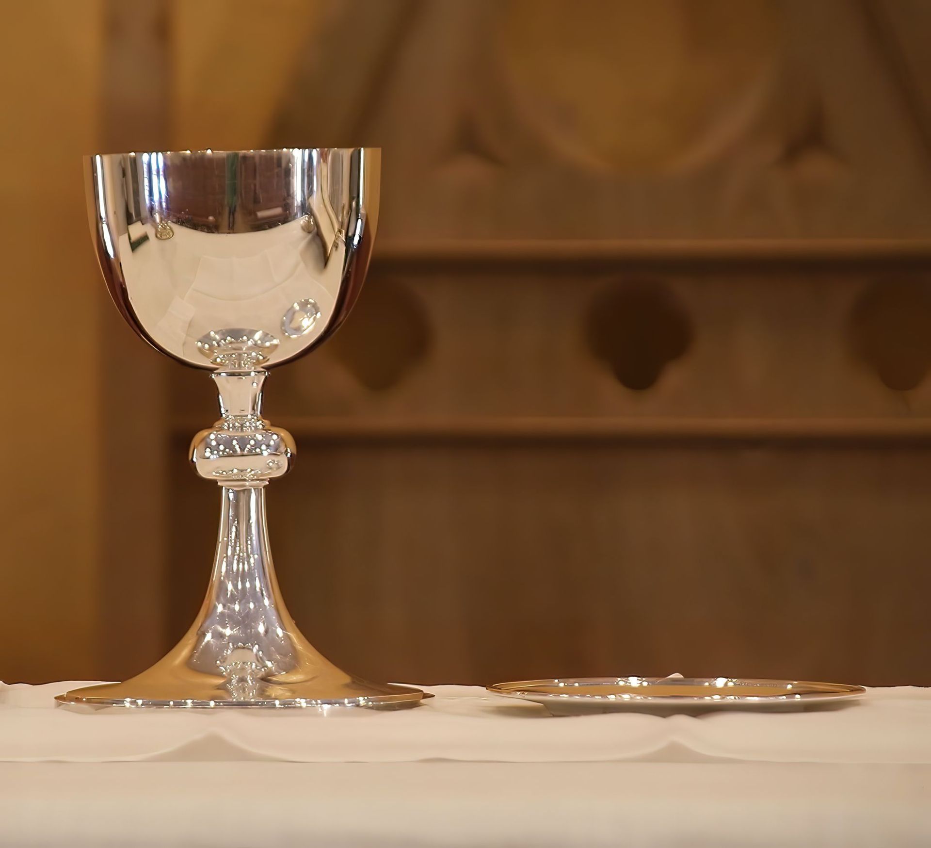 Picture of a chalice and paten on an altar.