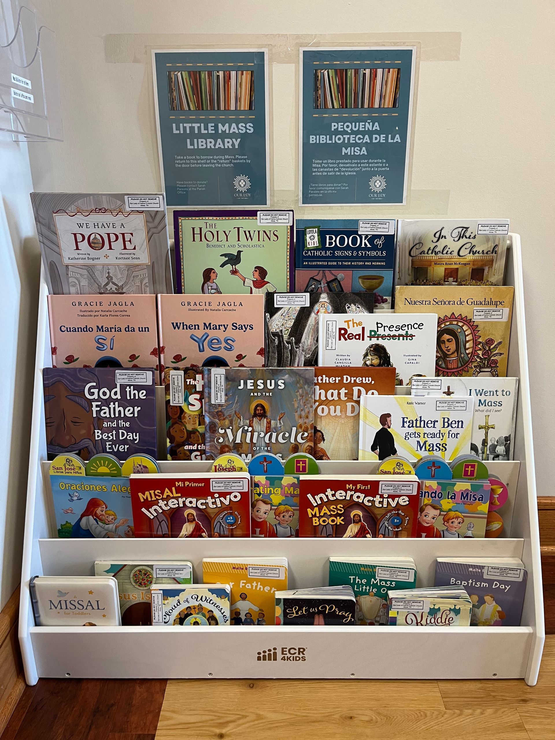 White bookshelf with various children's books displayed. Two posters above the books.