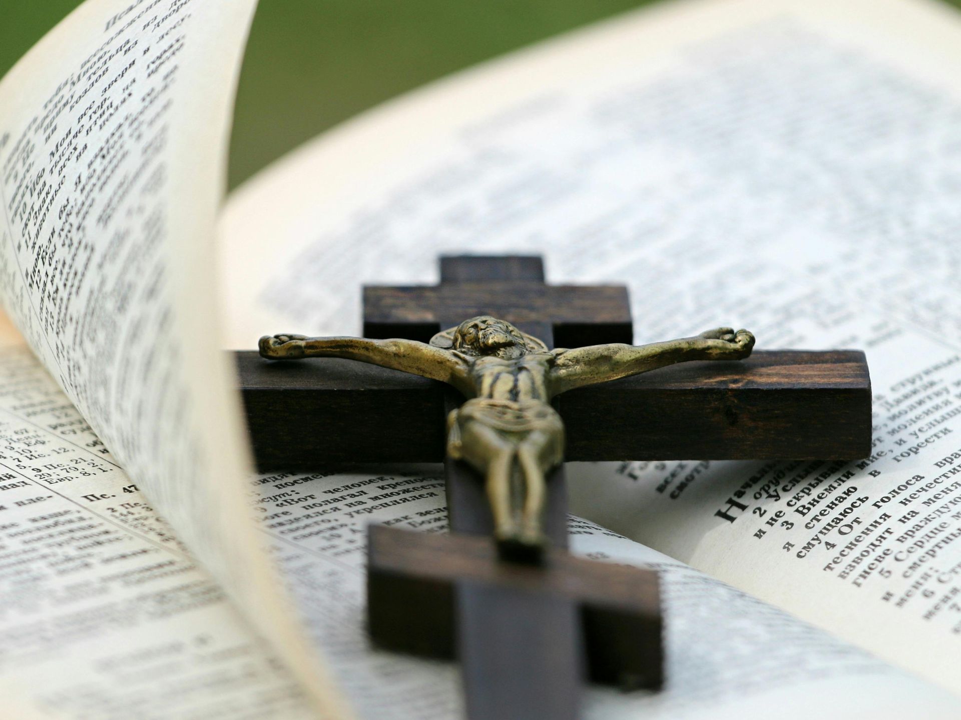 A cross is sitting on top of an open bible