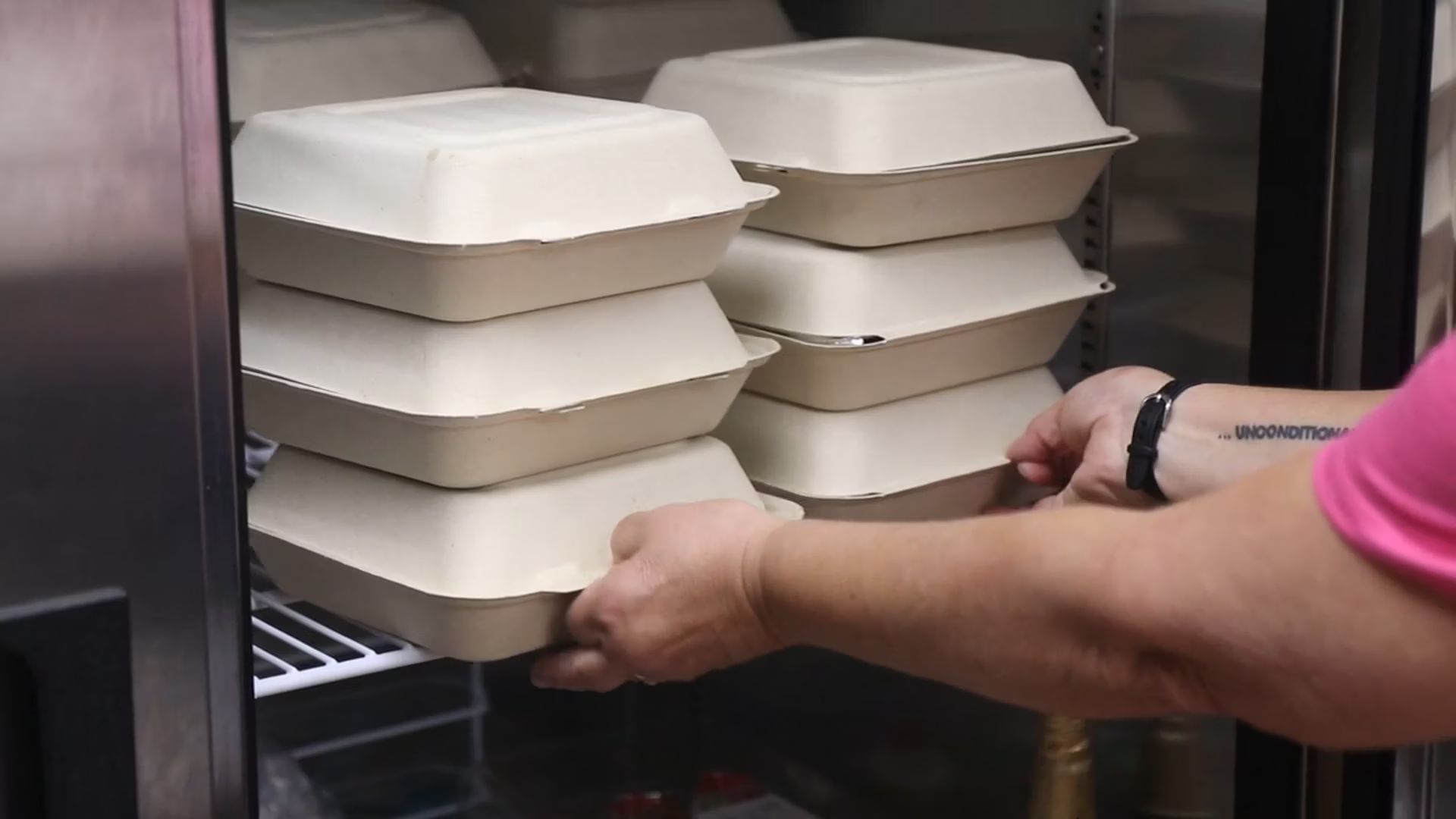 Picture of Martha's Hands volunteer taking to-go boxes out of the warmer