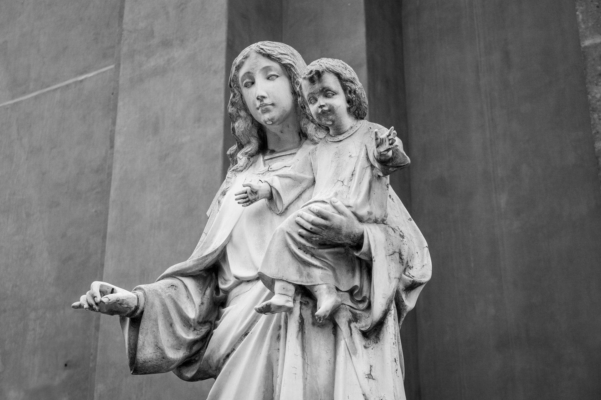 A black and white photo of a statue of a woman holding a child.