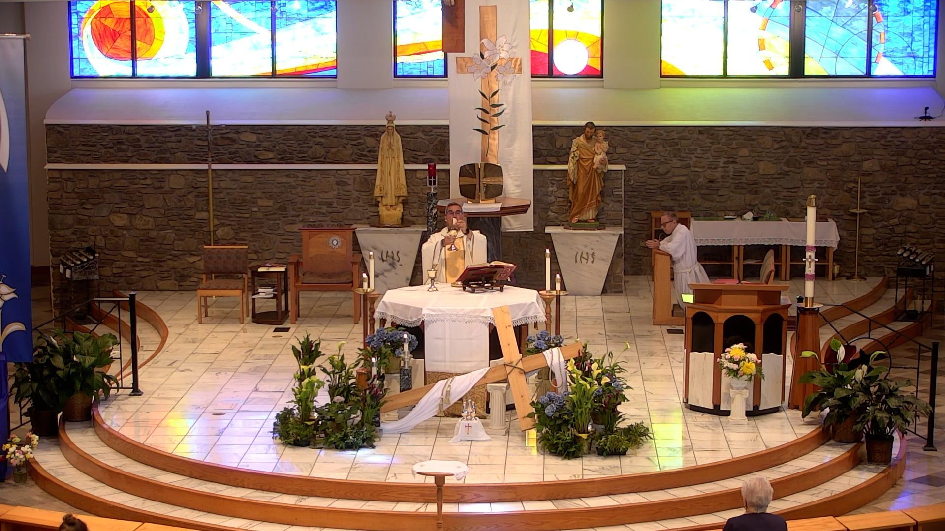 Fr. Pete celebrating mas inside of a church with stained glass windows