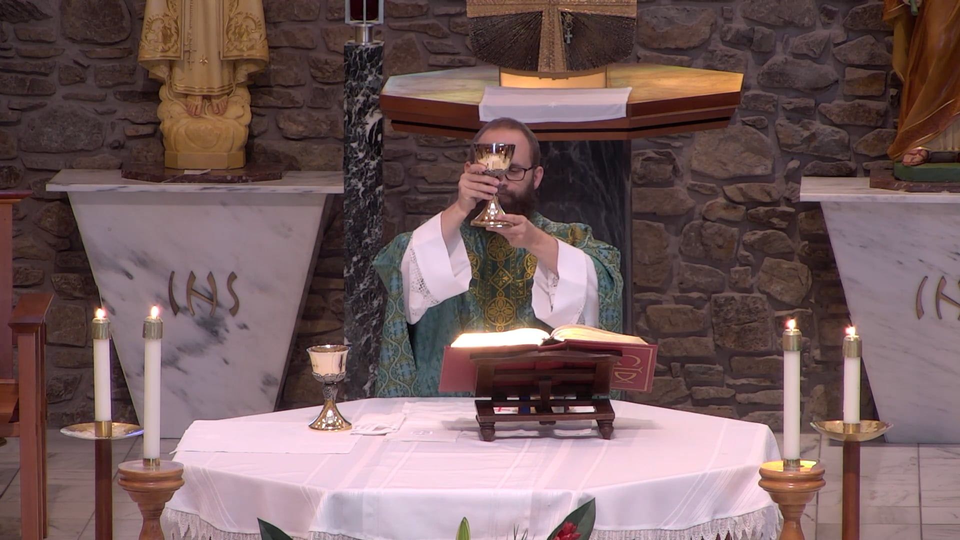 Father Joe holding up the chalice at the altar in the main church. 