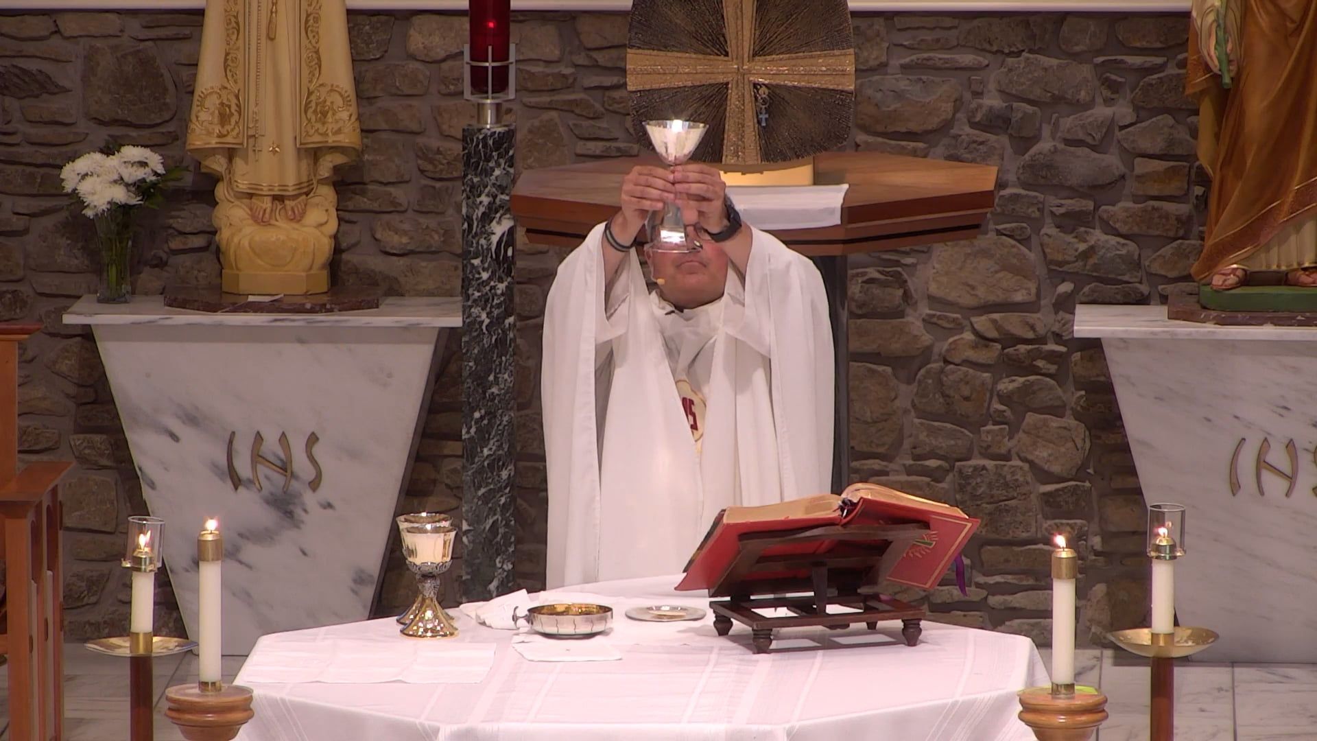 Father Pete holding the chalice celebrating mass in the main church. 