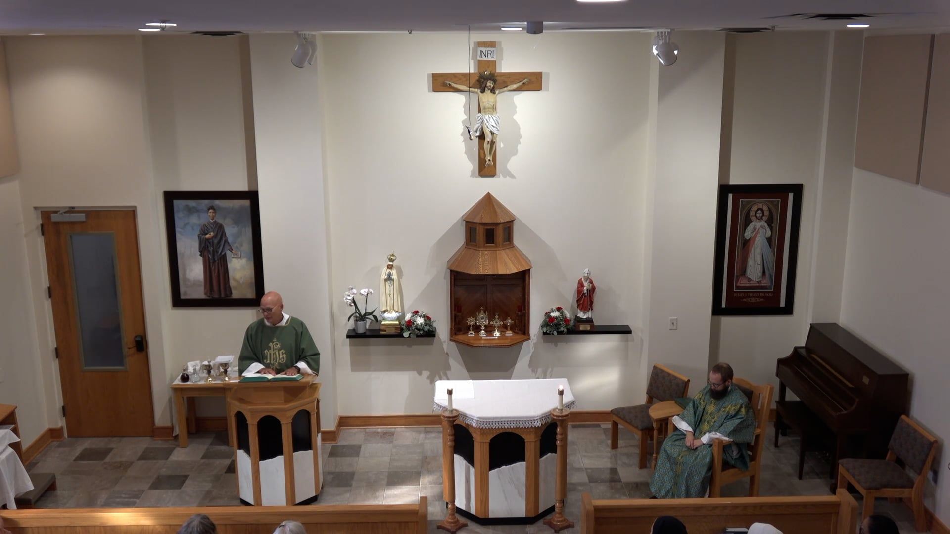 Deacon Bill at the ambo in the chapel with Fr. Joe celebrating mass. 
