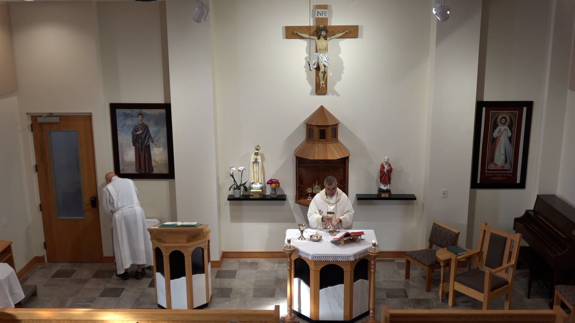 Father Pete in the chapel celebrating mass  looking down at the chalice. 