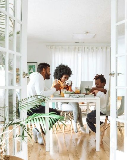A man and a woman are sitting at a table eating food.