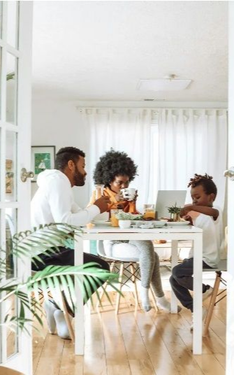 A man and a woman are sitting at a table eating food.