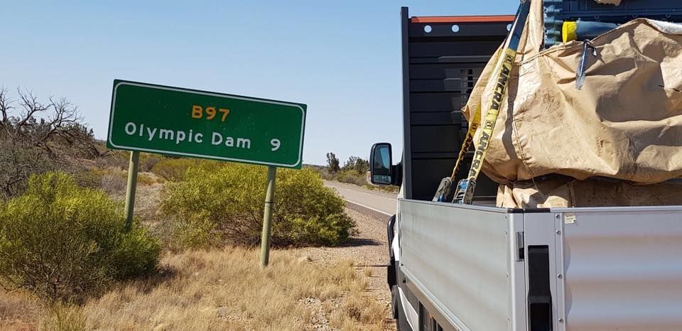 Truck is Parked in Front of a Green Sign That Says Olympic Dam — Pit Express in Rutherford, NSW