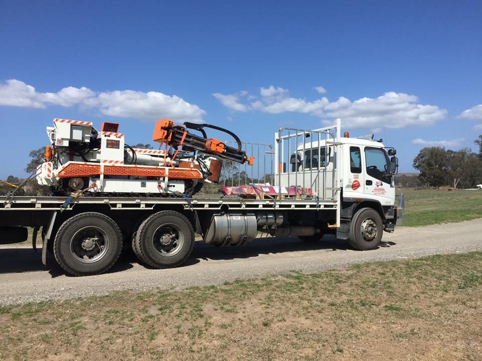 Truck is Carrying a Machine on the Back of It — Pit Express in Smeaton Grange, NSW